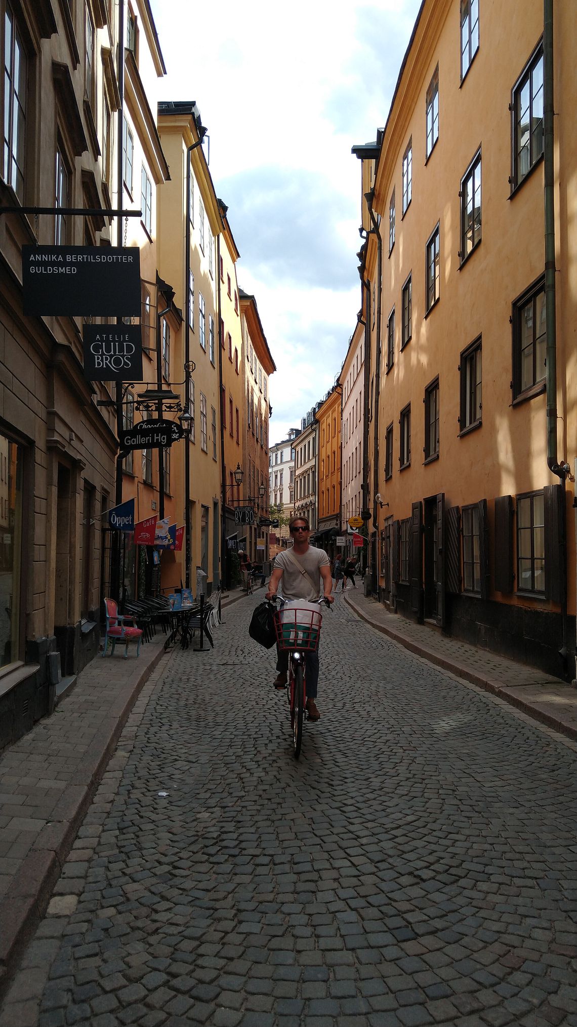 Man on bicycle on a cobbled narrow street.