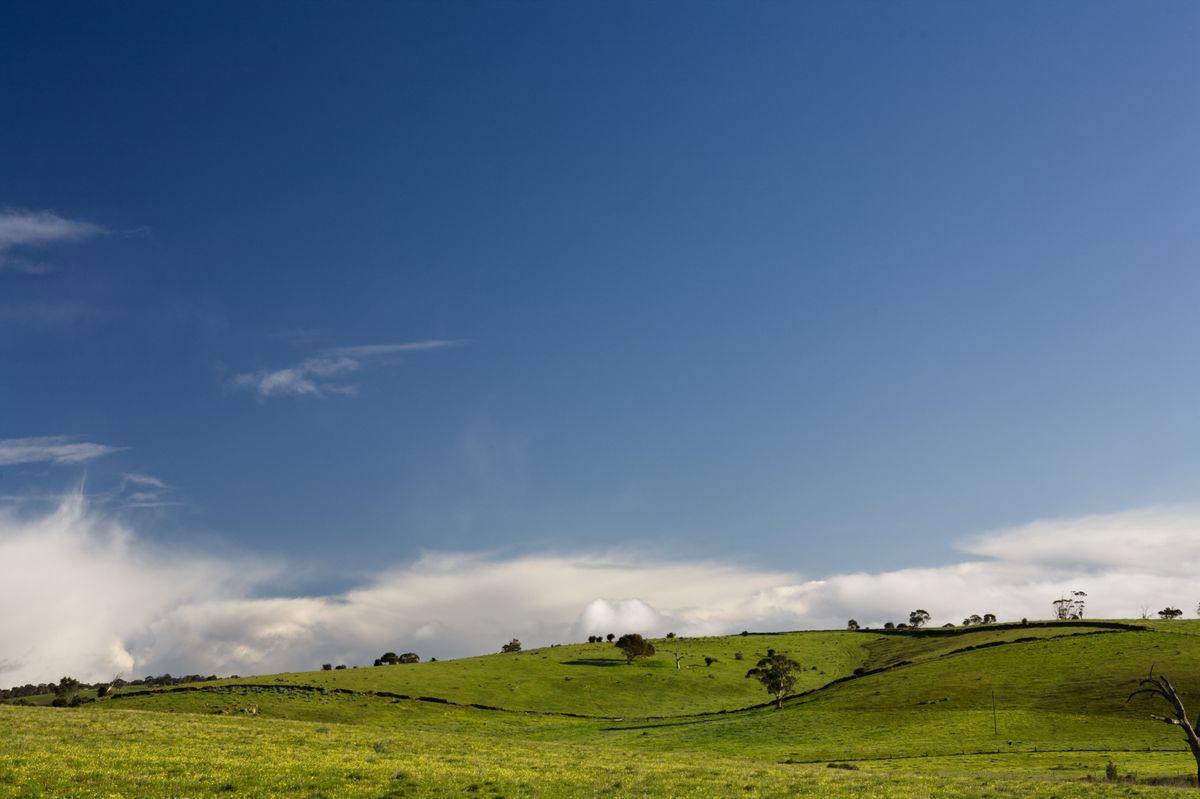 Green hills with rock wall and blue sky
